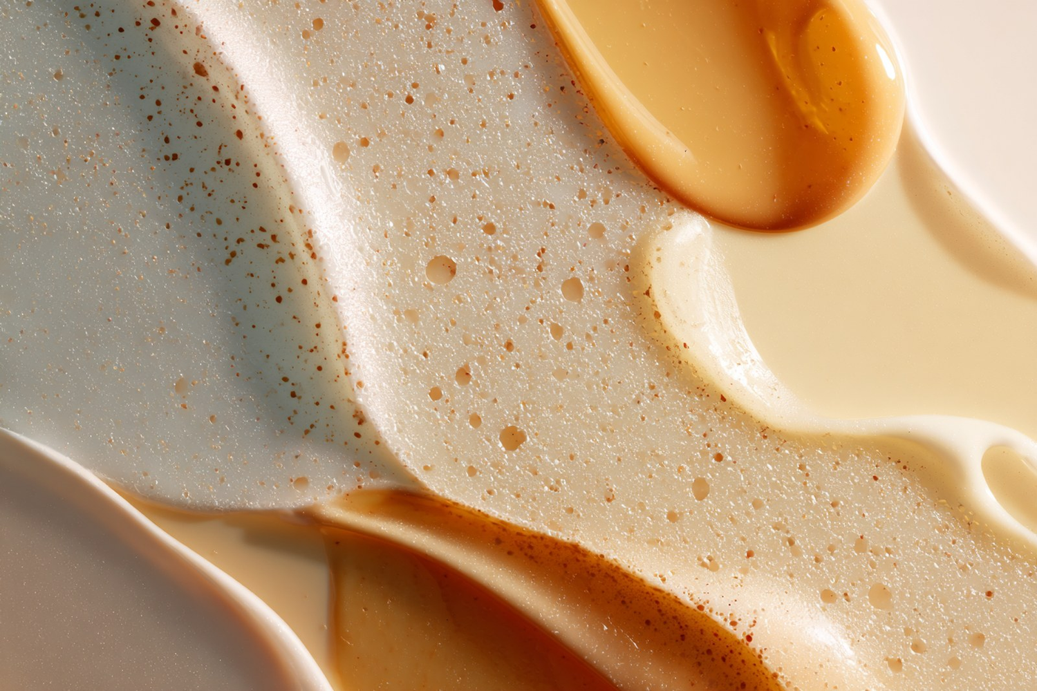 Glossy translucent cleansing textures on a warm neutral surface