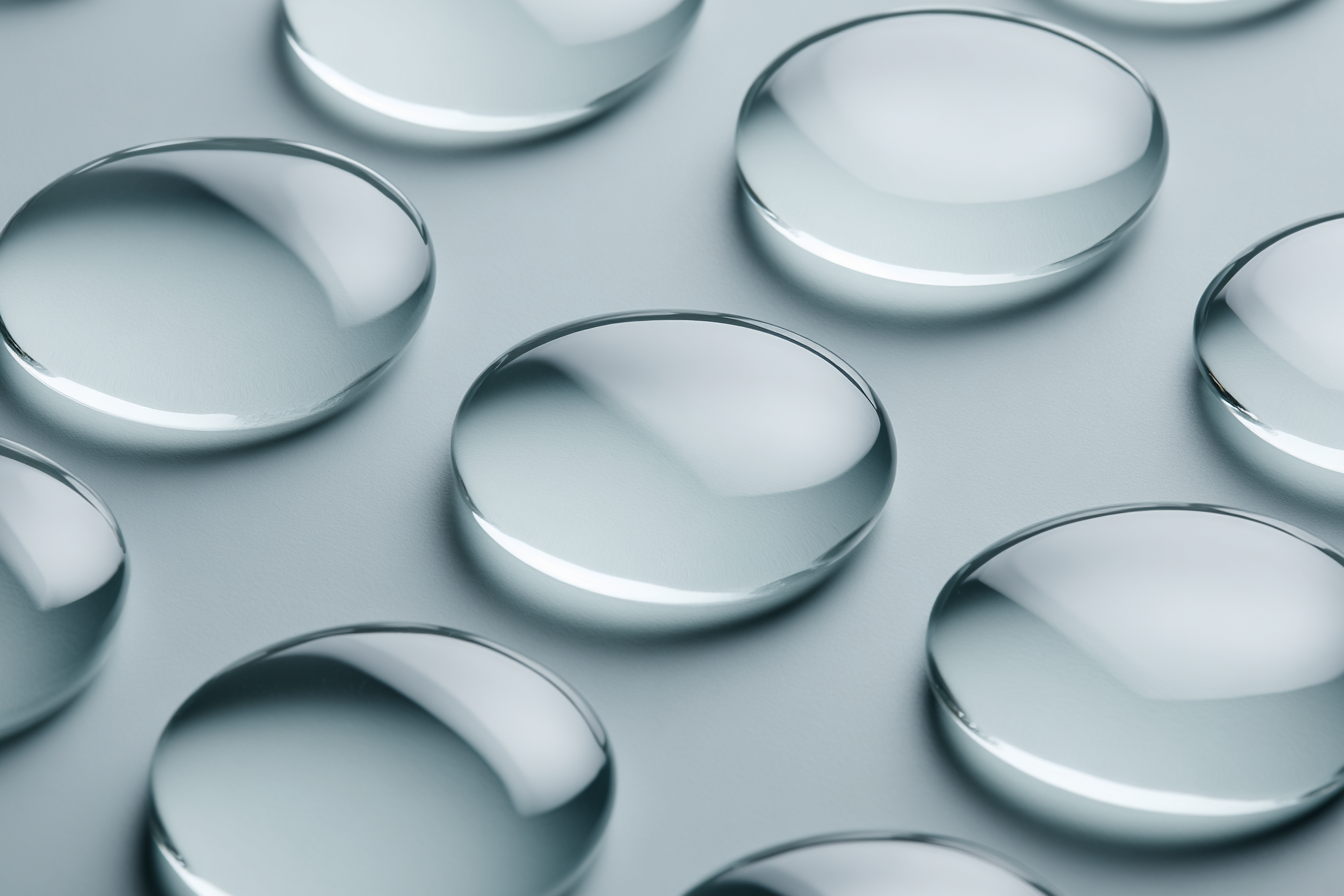 A grid of clear gel droplets on a cool surface