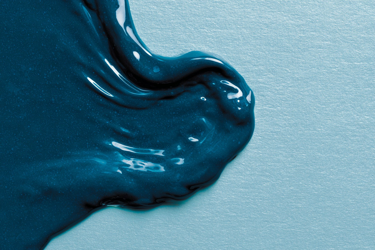A teal gel texture on a pale surface, suggesting a calm skincare routine