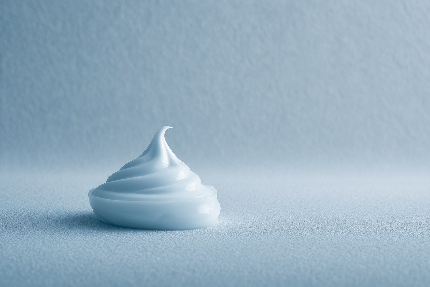 A soft swirl of pale cream on a calm powder-blue surface