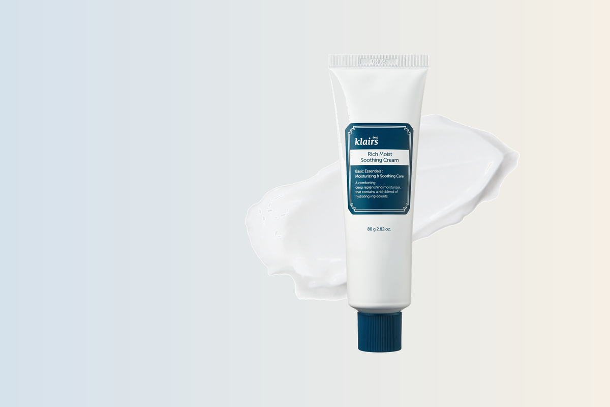 Klairs Rich Moist Soothing Cream tube with a cream swatch on a soft blue-to-cream gradient