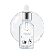 Klairs Freshly Juiced Vitamin Drop bottle inside a clear circular frame on a white background