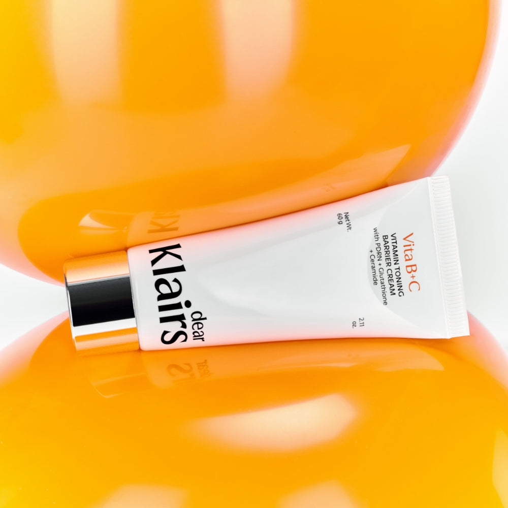 Vitamin Toning Barrier Cream tube on bright orange vitamin texture background