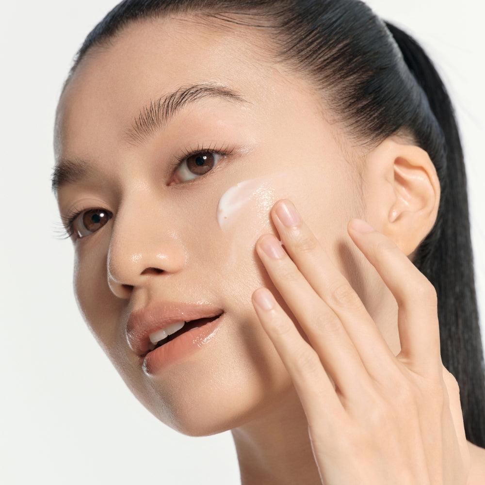 Model applying Vitamin Toning Barrier Cream to cheek